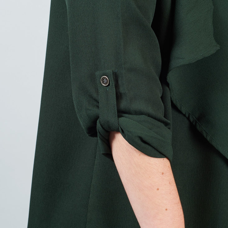 button tab on the sleeve of a green jacket-like shirt