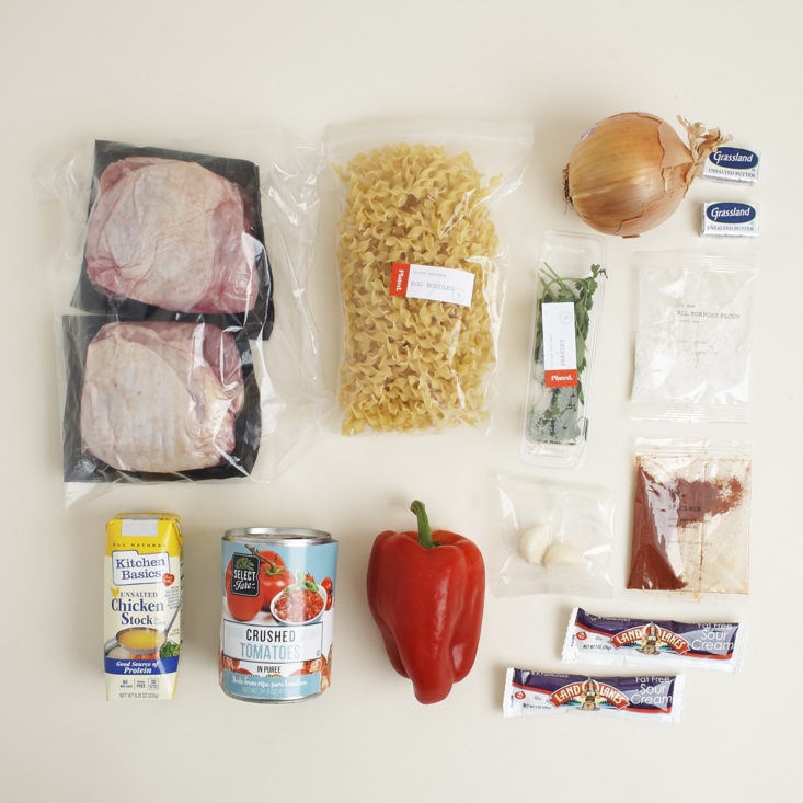ingredients for chicken paprikash with bell pepper and egg noodles laid out