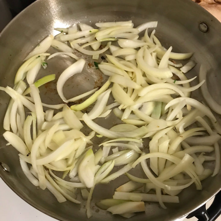sliced onions sauteing in pan
