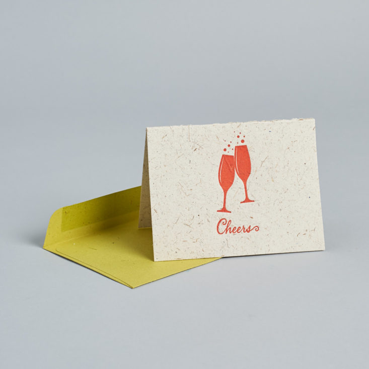 Recycled fibers make up this card, which has two red cheersing flutes on the front.