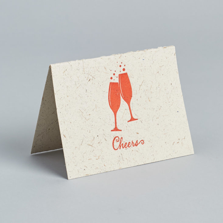 This greeting card says "Cheers" and features two red champagne glasses clinking together.