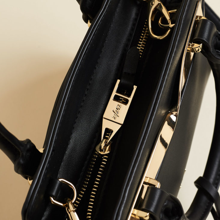 closeup on zipper of a black handbag