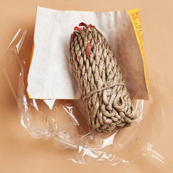 unwrapping a bundle of rope-like incense