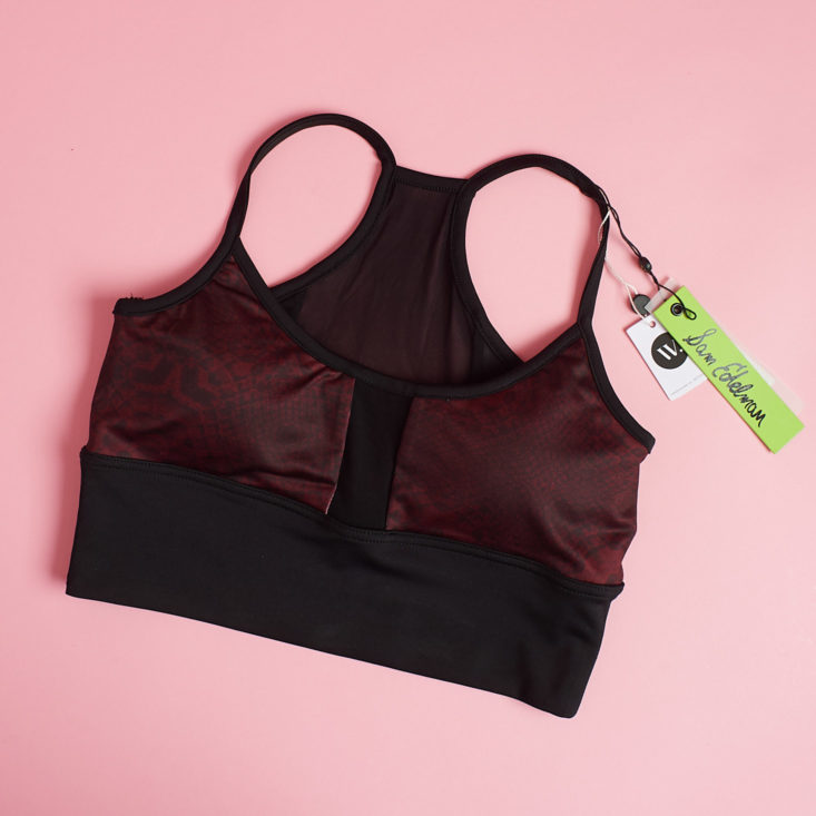 sheer burgundy bra laid down on a pink background