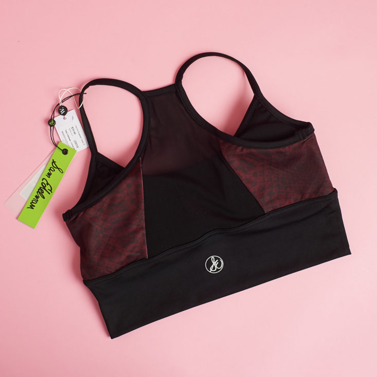 sheer burgundy bra from the back laying on a pink table
