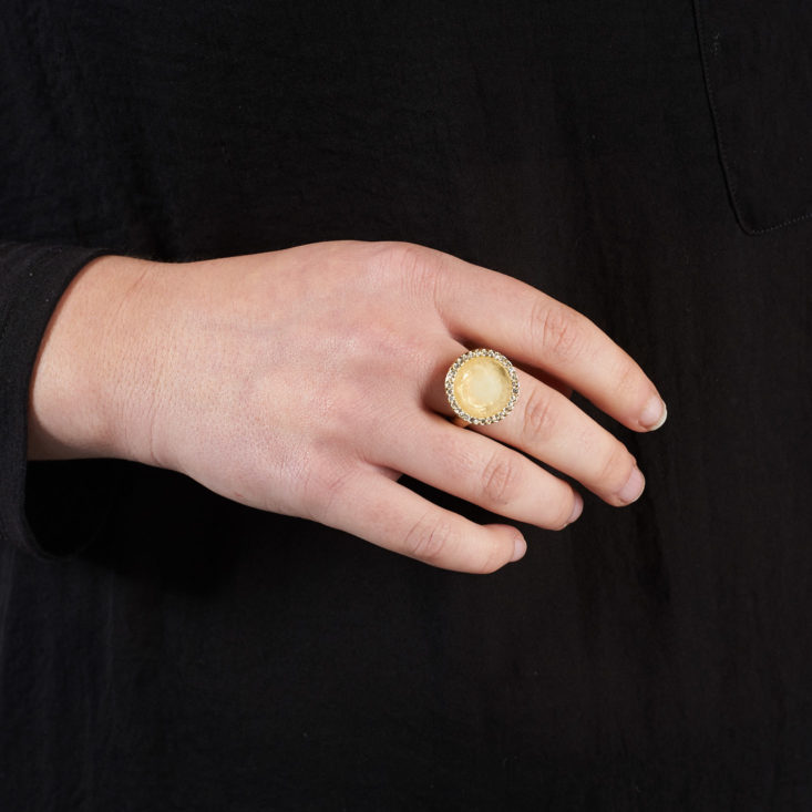 cloudy yellow circle shaped ring on a hand