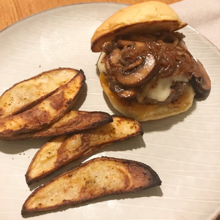 close up of plated mushroom swiss cheeseburgers with potato wedges
