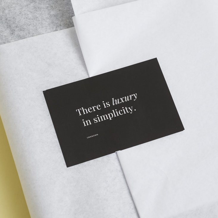 close up of sticker on tissue paper that says "there is luxury in simplicity"