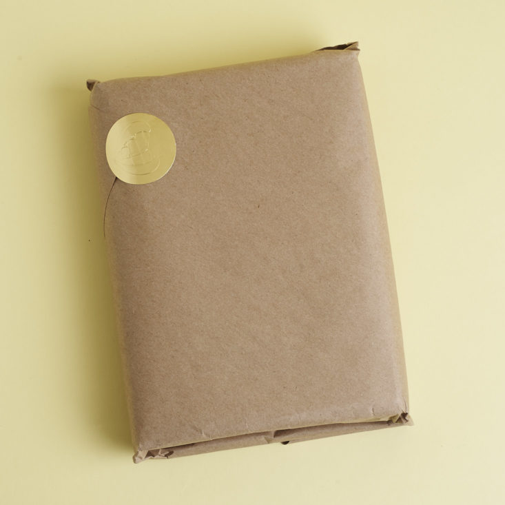 brown paper wrapped package with gold sticker