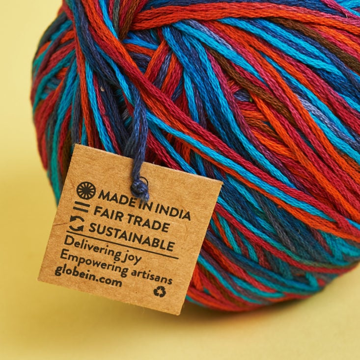 Sustainable, fair trade, and made in India tag on this red and blue yarn.