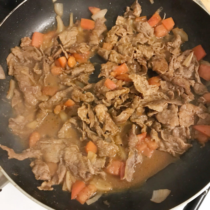 steak strips cooking with shallot, tomato, and seasoning