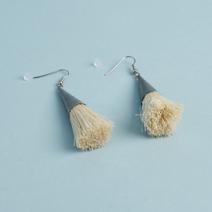 close up of metal and straw tassel earrings