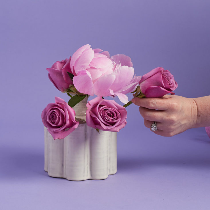 placing roses around the vase