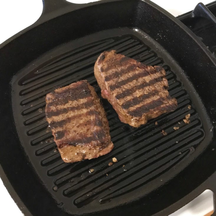 steaks cooking in grill pan