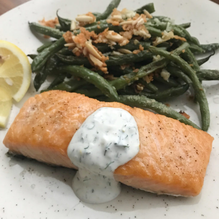 close up of finished Salmon with Dill Crema and green beans amandine