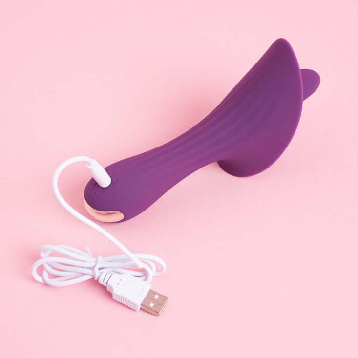 The Loving Orchid Vibrator with charging cord plugged in