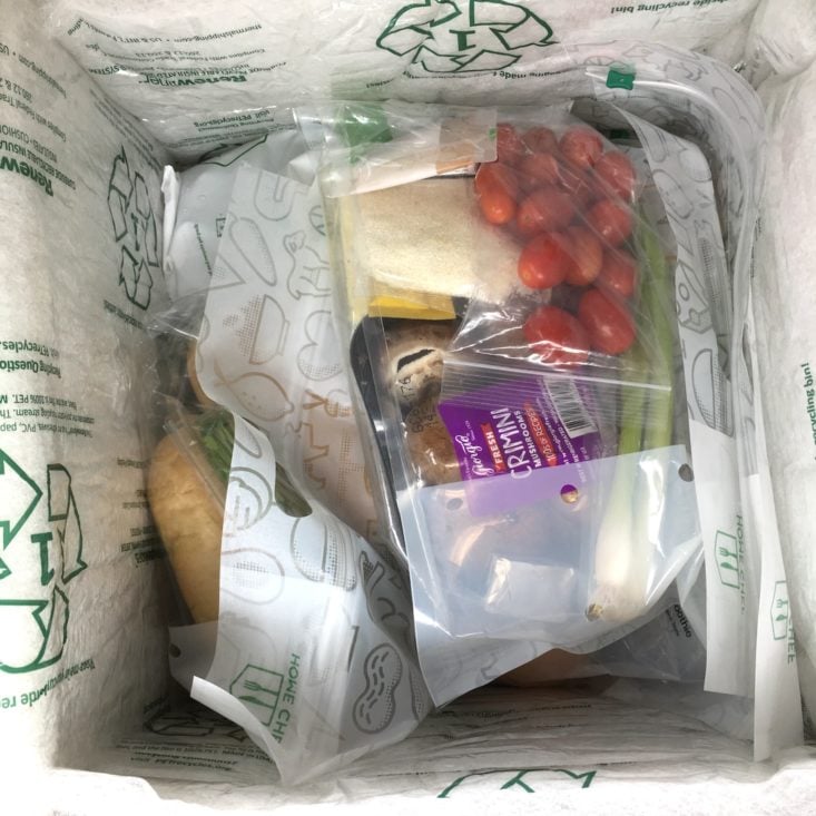 a top-down view of all the bagged recipe ingredients inside the insulated home chef box