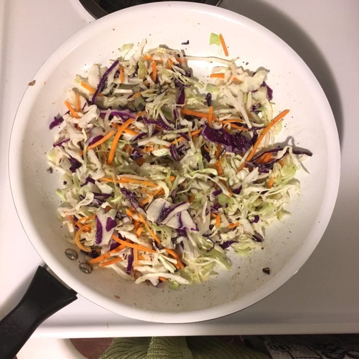 slaw mix cooking in a large white skillet