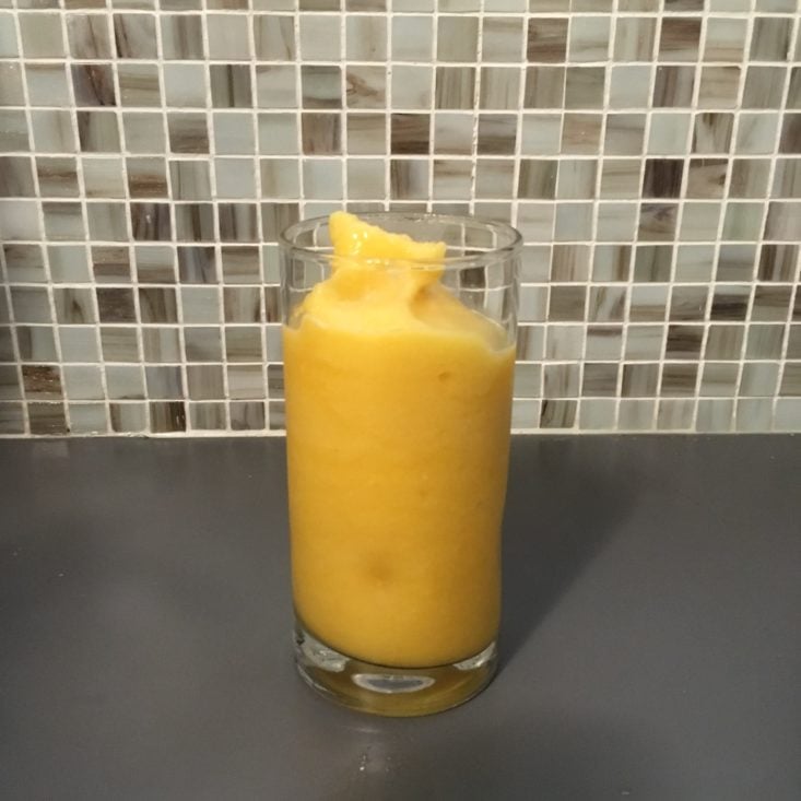 completed pineapple passion smoothie against a tile backsplash