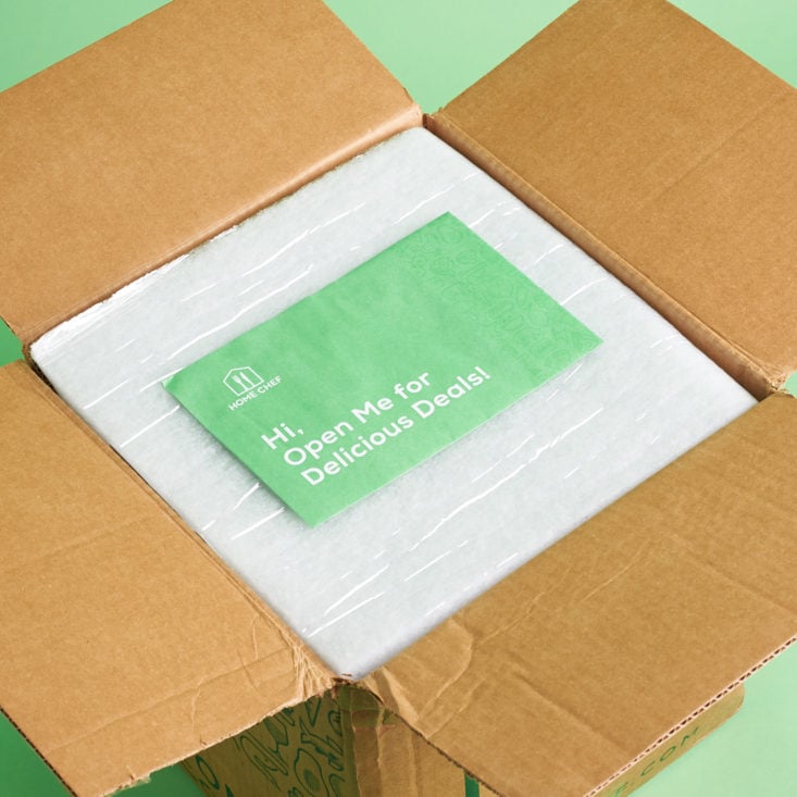 open box view showing a green envelope and recyclable insulation inside