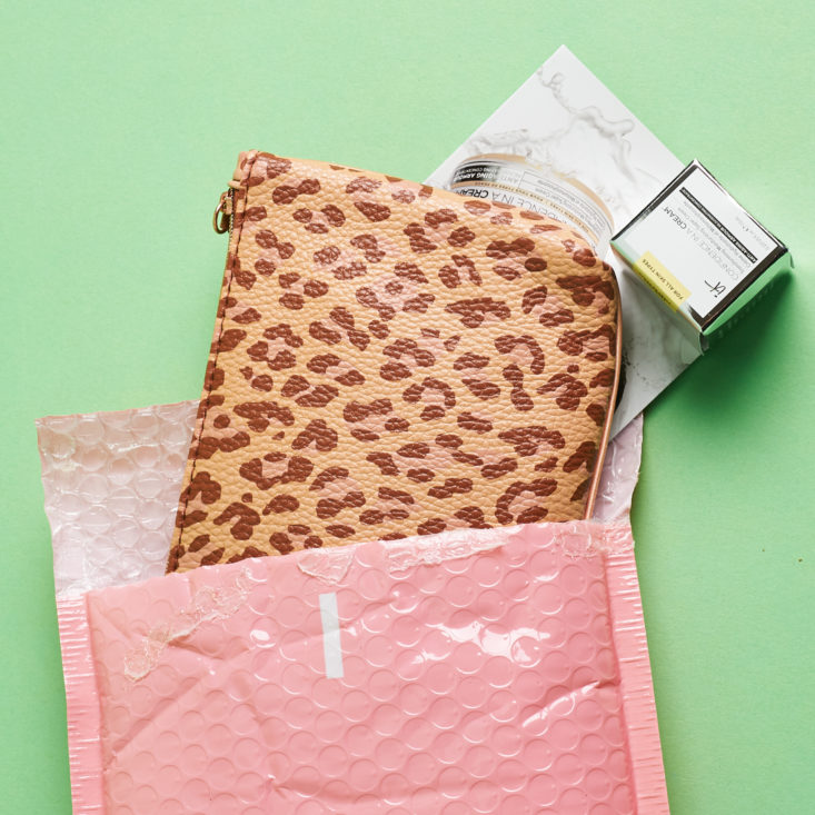 opening pink mailer to show leopard print bag