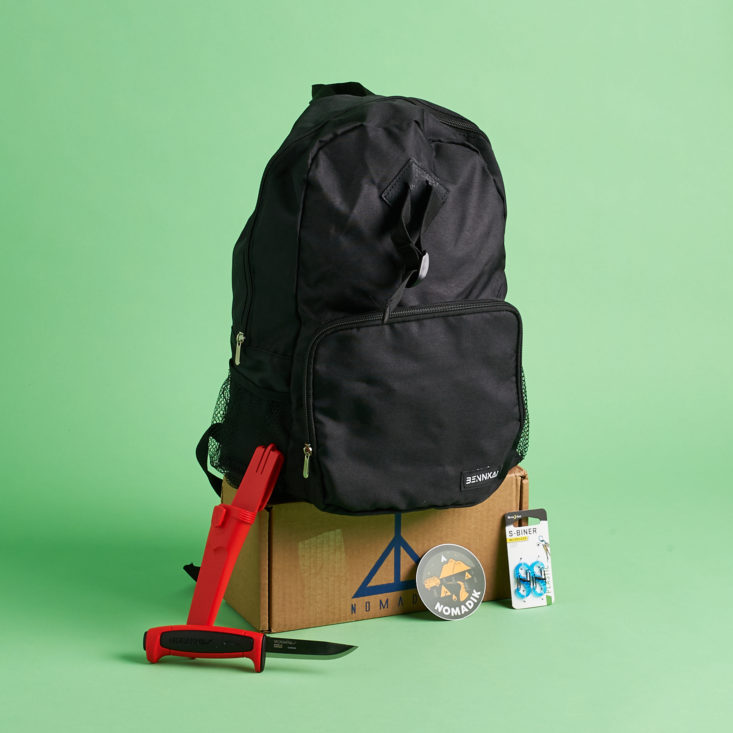 backpack, knife and clips surrounding Nomadik box